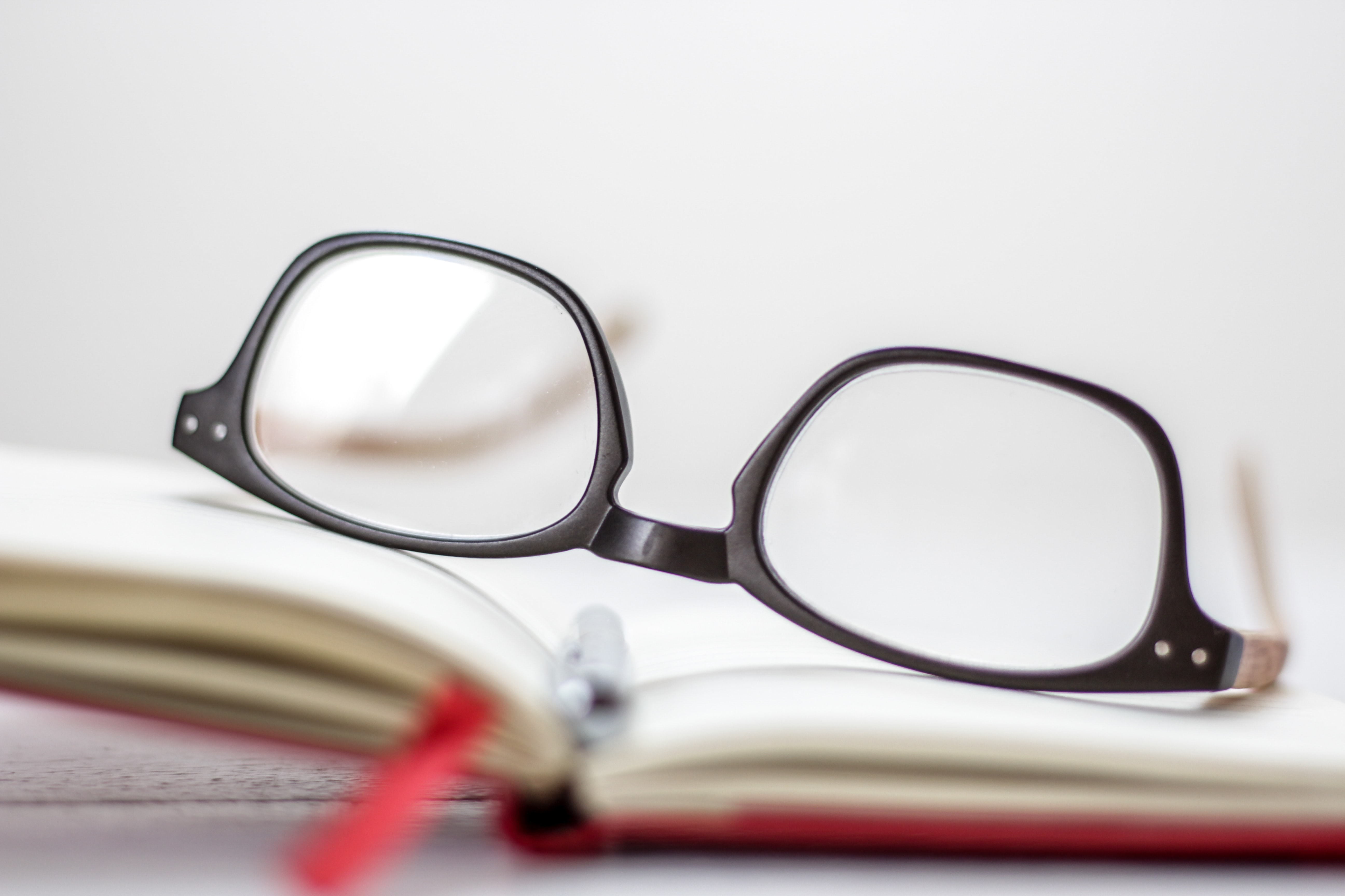 photo of a pair of eyeglasses resting on a book